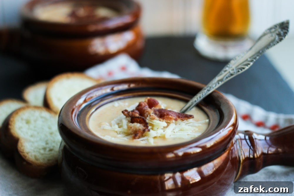 Hearty Ale and Cheddar Soup 4 A hearty serving of Cheddar-Ale Soup in a rustic bowl, topped with crispy bacon and green onions.