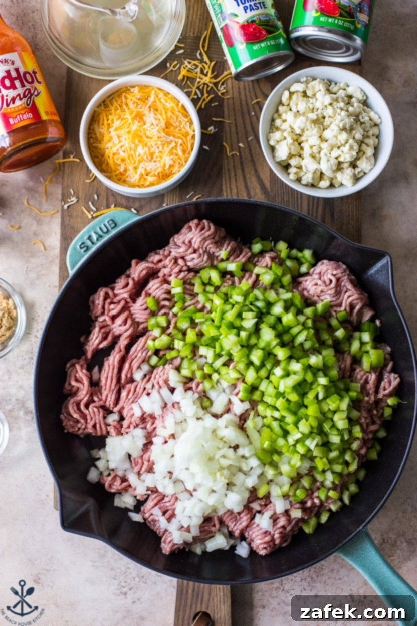 Spicy Buffalo Sloppy Joes 5 Overhead photo of a skillet with ground turkey meat, diced celery, and onions cooking until lightly browned.