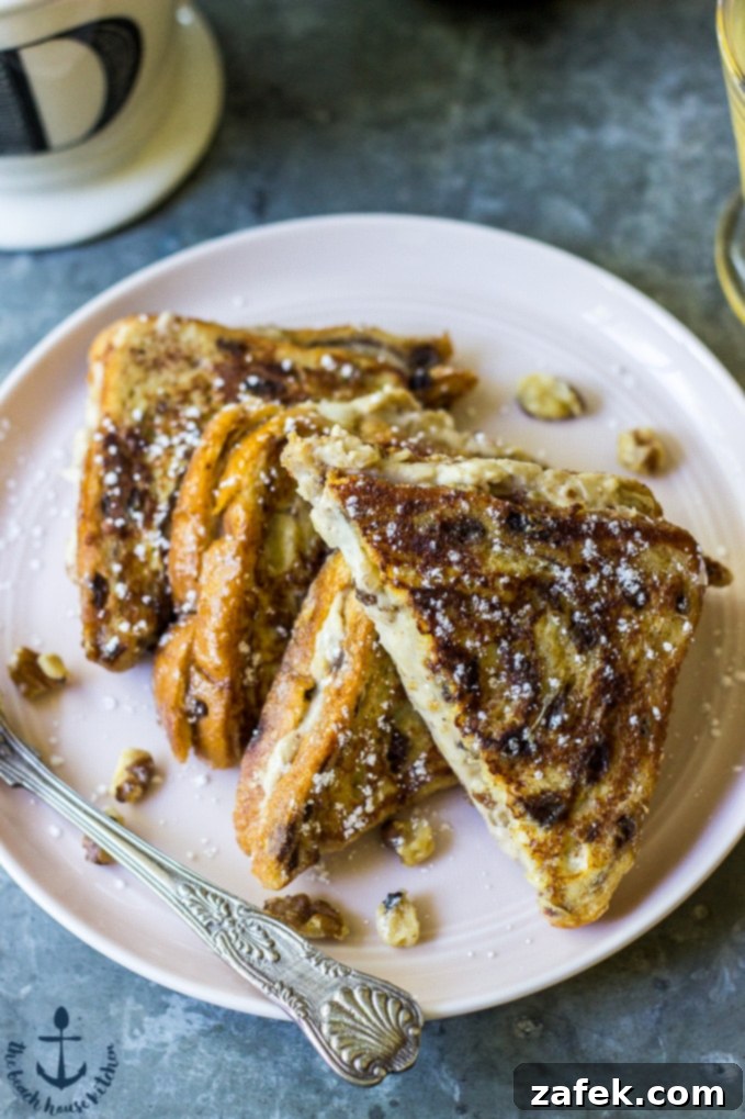 Walnut Cinnamon Cream Cheese Stuffed French Toast with powdered sugar and maple syrup