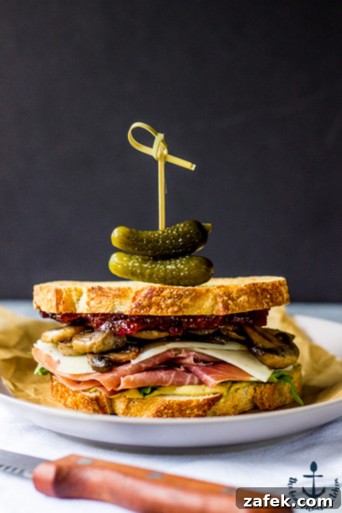 Assembling the Prosciutto and Asiago Sandwich with layers of ingredients