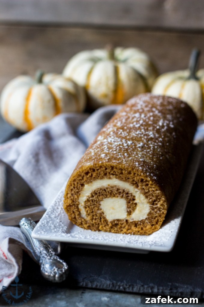 Spiced Pumpkin Swirl 2 Delicious Pumpkin Roll dessert, perfect for fall holidays and gatherings, showcasing its elegant swirl.