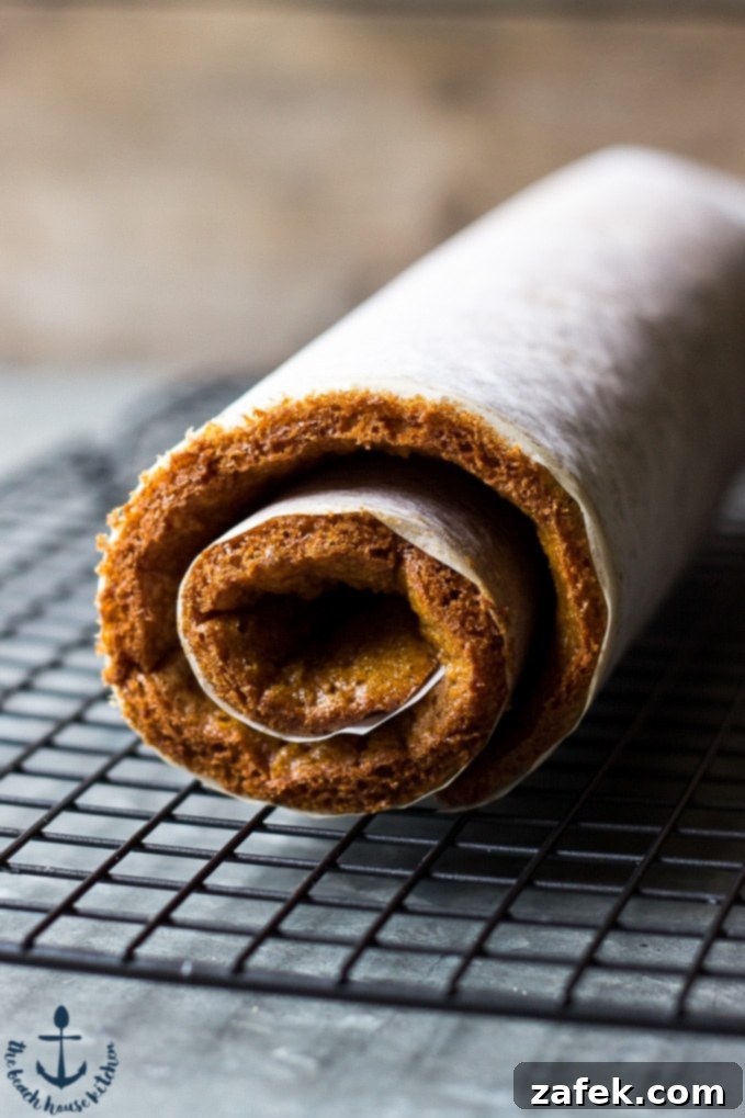 Spiced Pumpkin Swirl 6 A whole Pumpkin Roll displayed on a beautiful white platter, lightly dusted with confectioner's sugar, ready to be sliced and served.