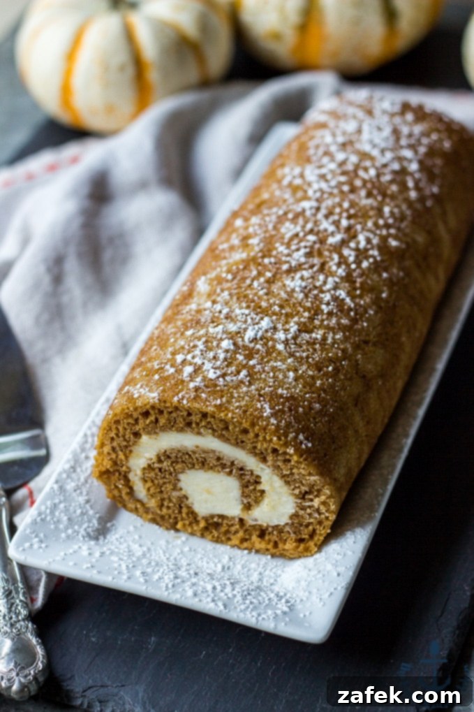 Spiced Pumpkin Swirl 7 Arrangement of several neat slices of Pumpkin Roll on a rustic white plate, emphasizing the spiral pattern and inviting texture.