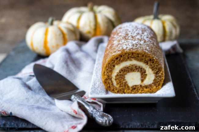 Spiced Pumpkin Swirl 8 A platter of beautifully prepared Pumpkin Roll slices, garnished with a light dusting of powdered sugar, ready for guests.