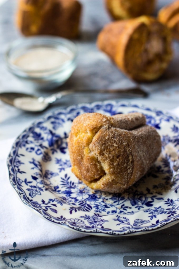 Aromatic Chai Clouds 4 A plate of Chai Spiced Popovers with a cup of tea, set against a bright background