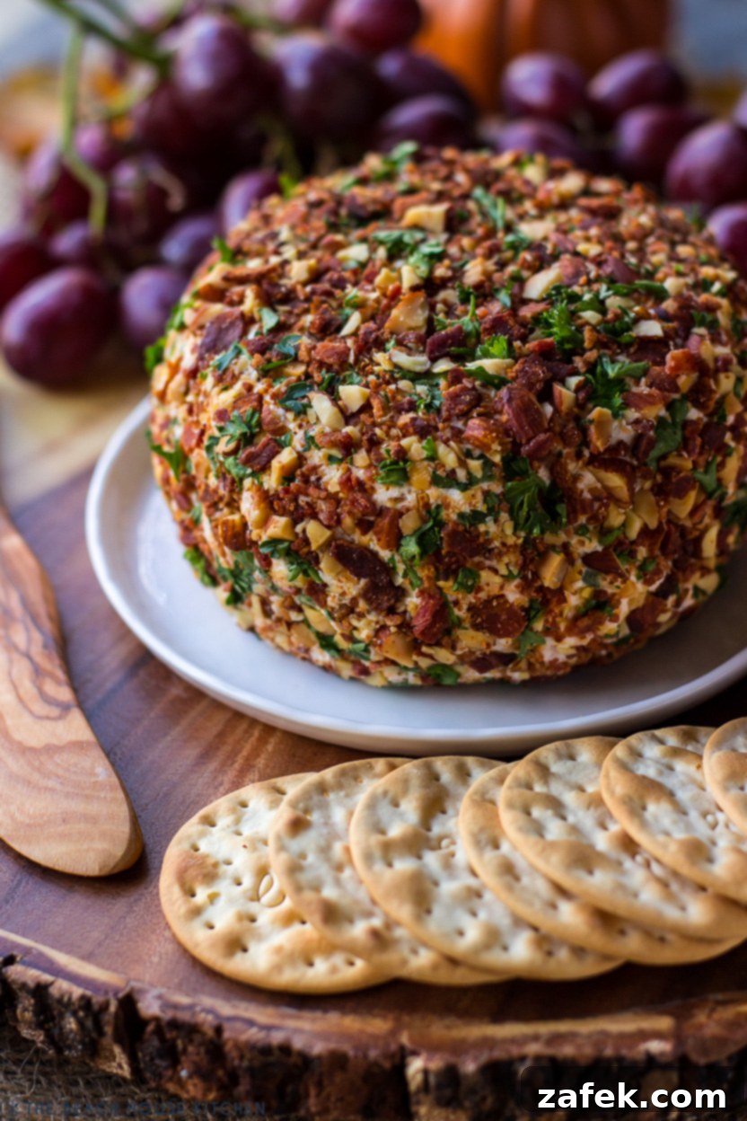 A close-up, appetizing view of a Jalapeño Bacon Ranch Cheese Ball, showcasing its textured coating of bacon, almonds, and parsley, ready to be enjoyed.