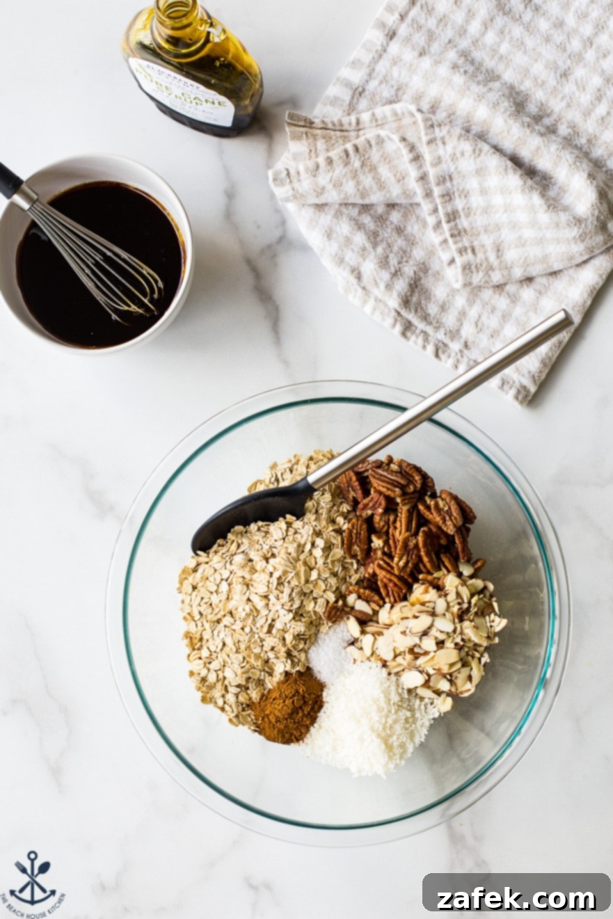 Overhead photo of glass bowl filled with ingredients for maple cinnamon granola