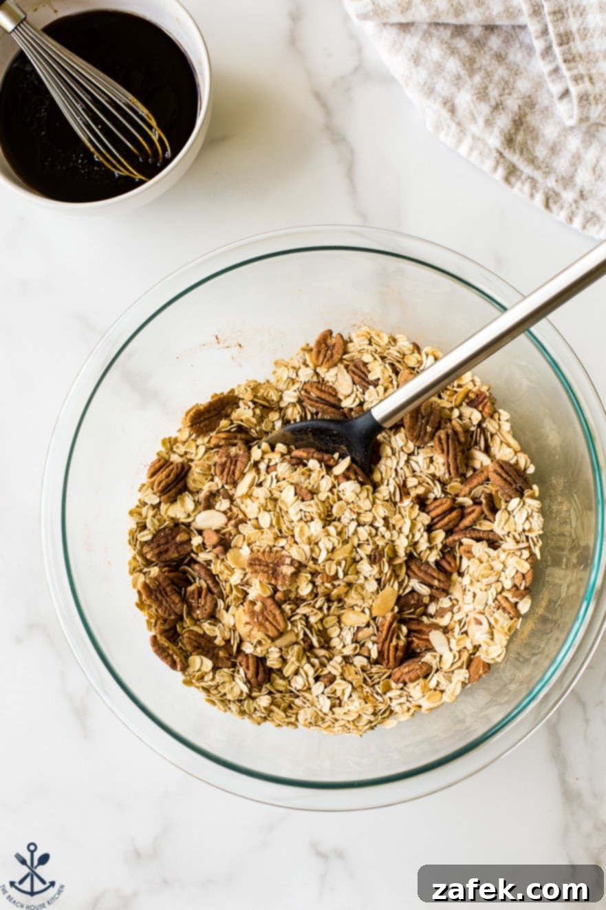 Overhead photo of glass bowl filled with ingredients for maple cinnamon granola