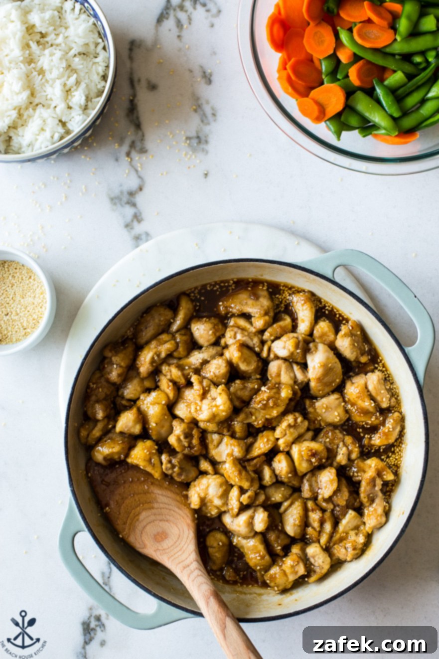 Effortless Sticky Sesame Chicken 6 A skillet of cooked sesame chicken, beautifully glazed with the rich, sweet, and tangy sauce.