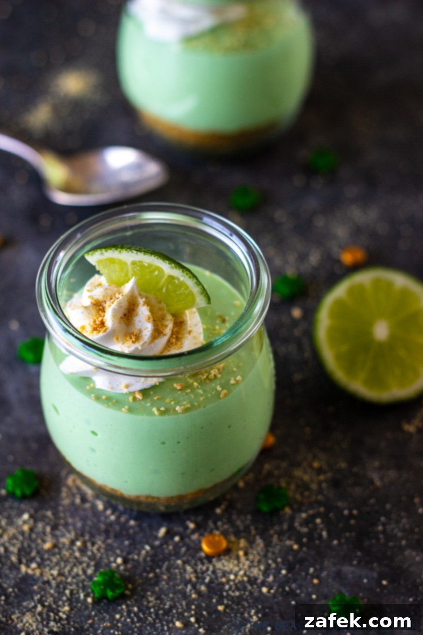 A vibrant green Mini No Bake Key Lime Pie Cheesecake served in a small clear jar, perfect for St. Patrick's Day.