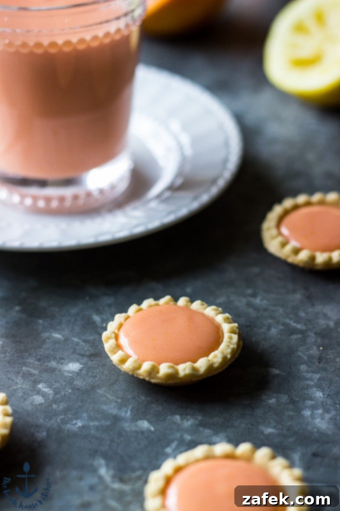 Sun-Kissed Ruby Curd 4 Close-up shot of the creamy texture of homemade Blood Orange Curd, showcasing its vibrant red-orange hue in a clear bowl