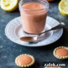 Sun-Kissed Ruby Curd 5 Blood Orange Curd in a pristine white bowl, with a vintage silver spoon dipping into its creamy texture