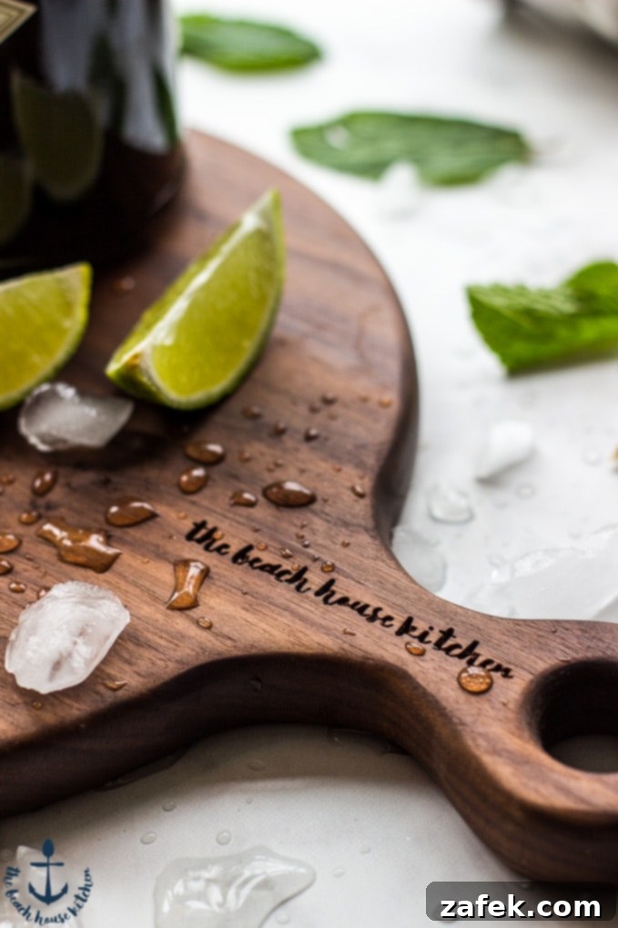 Scarlet Zest Gimlet 7 A Ruby Red Gimlet cocktail garnished with fresh mint on a stylish wooden board