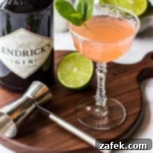 Scarlet Zest Gimlet 8 Close-up image of a Ruby Red Gimlet cocktail garnished with a fresh mint leaf