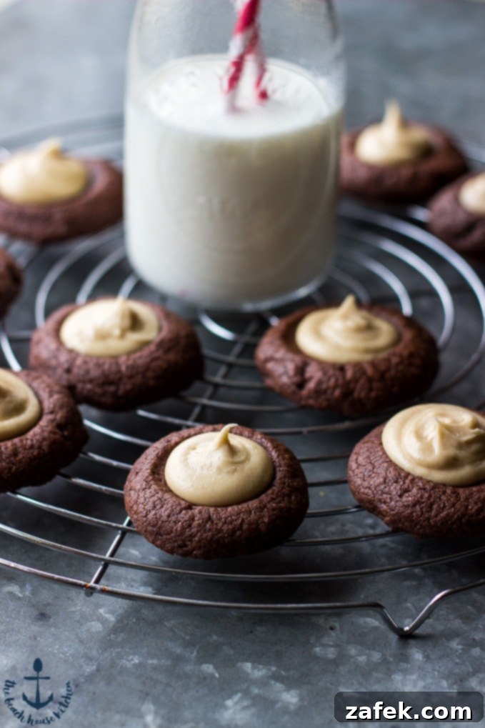Freshly baked Chocolate Peanut Butter Thumbprint Cookies cooling on a wire rack, ready for their delicious filling.