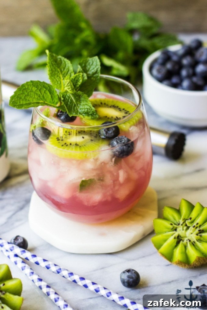 Zesty Berry Kiwi Mojito 5 A hand muddling blueberries, kiwi, and mint for a mojito.