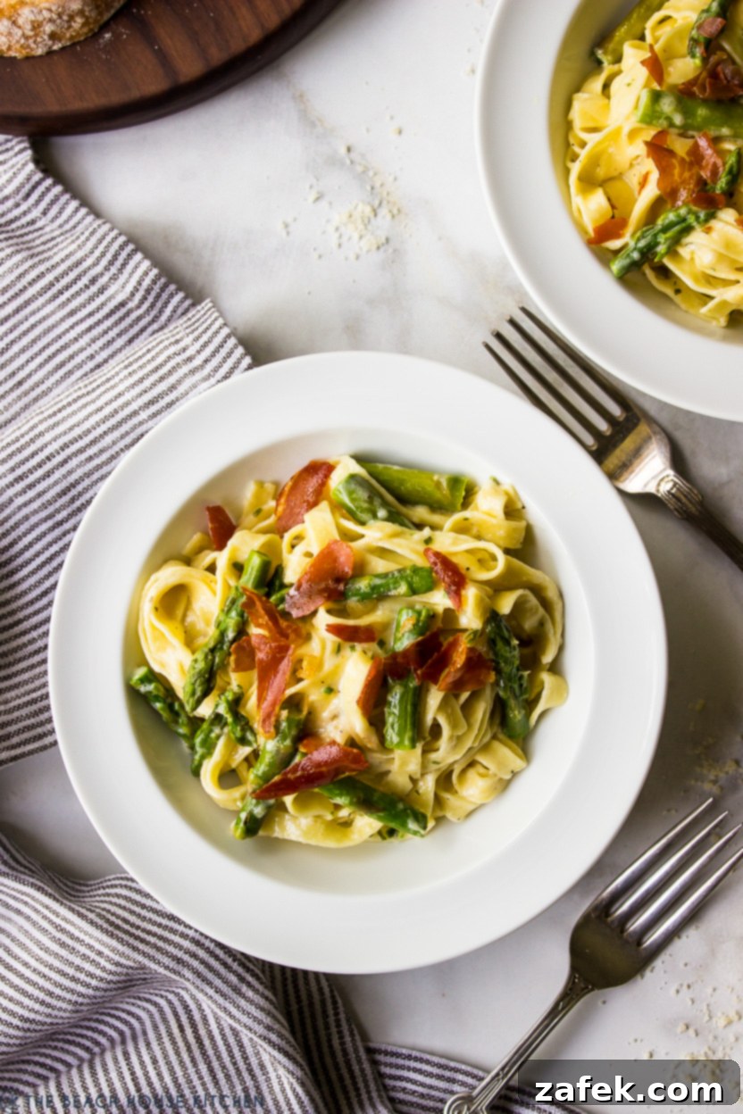 Crispy Prosciutto and Tender Asparagus Fettuccine Alfredo 3 Up close overhead photo of a bowl of Fettuccine Alfredo with Asparagus and Crispy Prosciutto, showcasing the creamy sauce and crisp toppings