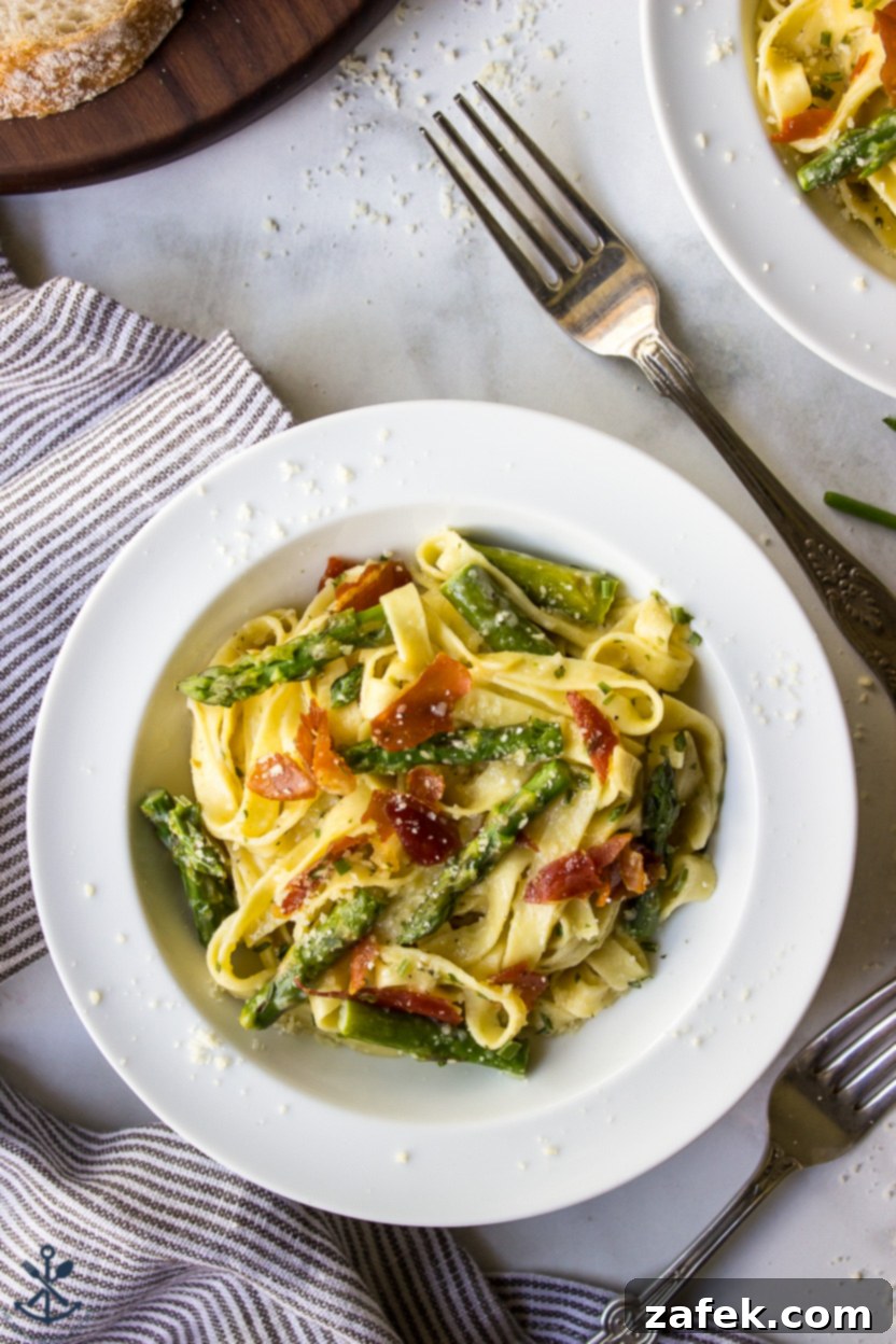 Crispy Prosciutto and Tender Asparagus Fettuccine Alfredo 6 Up close overhead photo of a bowl of Fettuccine Alfredo, showing the texture of the pasta and creamy sauce