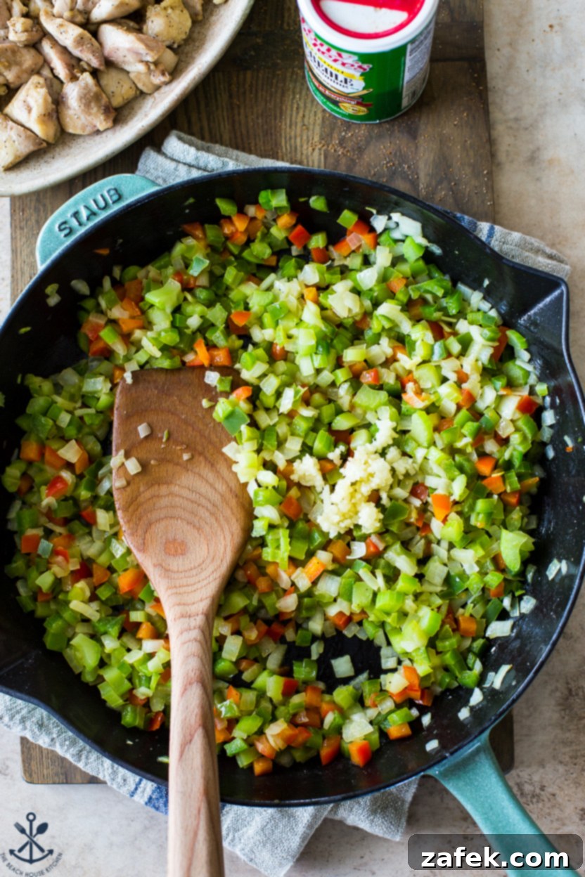 Bayou Jambalaya 7 Overhead photo of a skillet of cooked peppers and onions with a wooden spoon