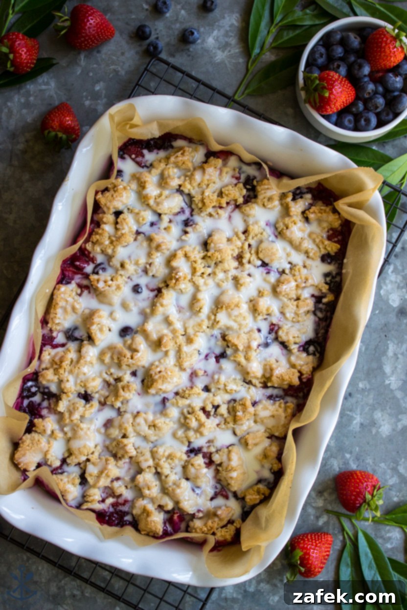 Summer Berry Streusel Bars 5 Overhead photo of baked berry crumb bars topped with a sweet vanilla glaze, ready to be cut and served.