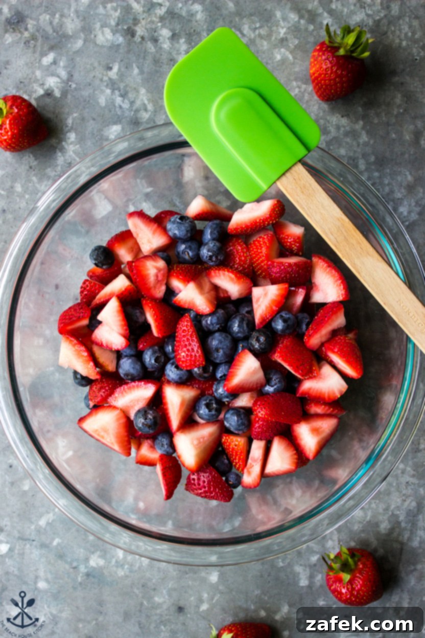 Summer Berry Streusel Bars 6 Overhead photo of a bowl filled with freshly chopped strawberries and plump blueberries, ready for the crumb bar filling.