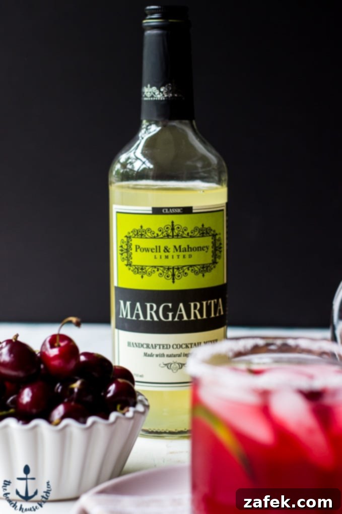 Ruby Cherry Margarita 4 A tray with a cocktail shaker, ingredients, and a prepared Cherry Margarita glass, ready for mixing.