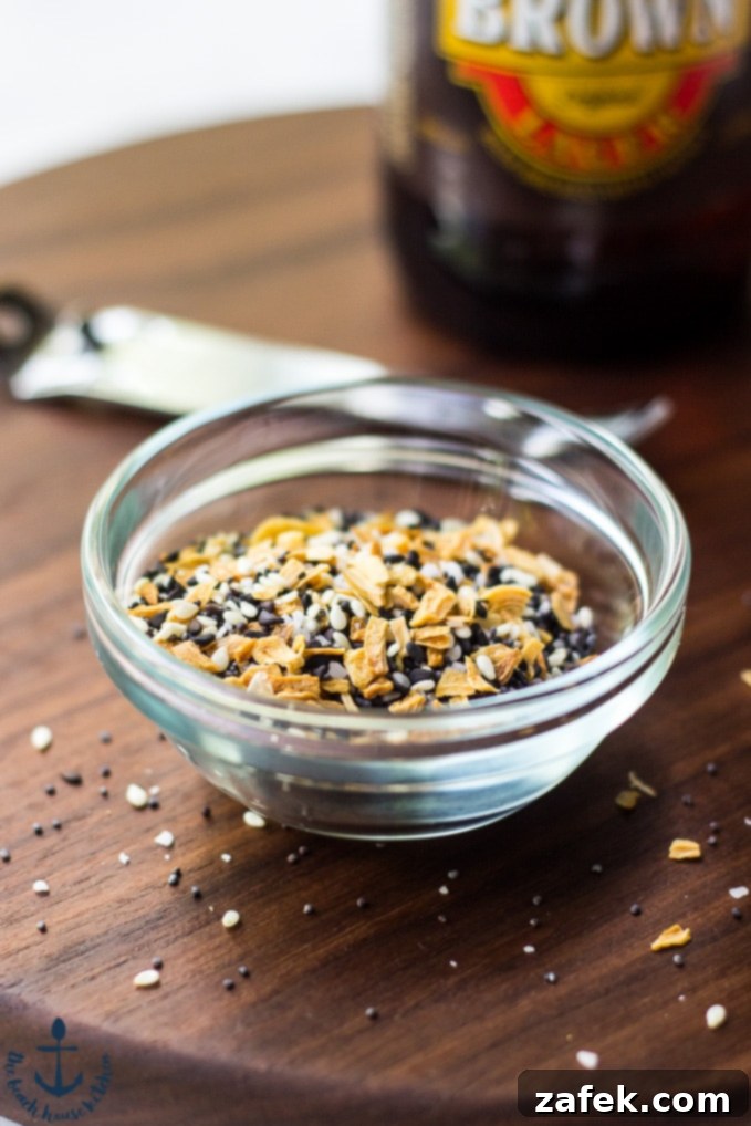 Creamy Cheddar Pub Cheese and Zesty Everything Pita Chips 5 Ingredients for Cheddar Pub Cheese, including grated cheddar, beer, and spices, laid out on a table.