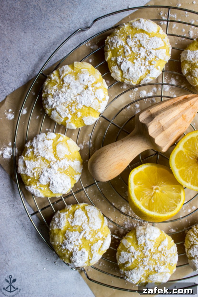 Overhead photo of freshly baked lemon cookies cooling on a round wire rack, some showing distinct crinkles