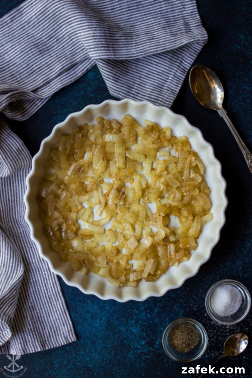Sliced raw vegetables including eggplant, zucchini, and tomatoes arranged on a cutting board, ready for layering