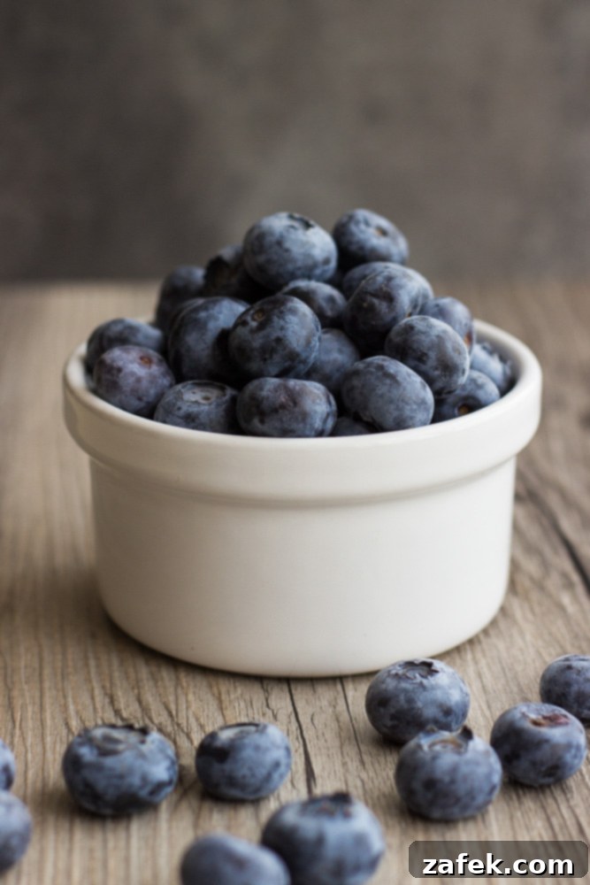 Fluffy Buttermilk Blueberry Stacks 3 Close-up of fresh, ripe blueberries, perfect for baking into pancakes, on a rustic surface.