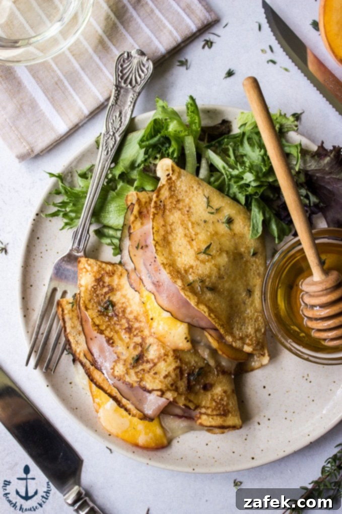 Close-up of freshly made Peach, Ham and Gruyere Crepes with a side salad