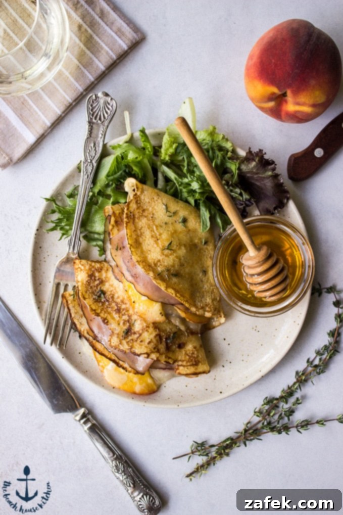 Three Peach, Ham and Gruyere Crepes folded into triangles on a plate