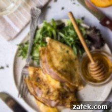 A small plate with a single folded Peach, Ham and Gruyere Crepe