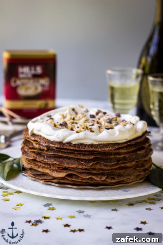 Double-Chocolate-Hazelnut-Crepe-Cake Exquisite Double Chocolate Hazelnut Crepe Cake elegantly presented on a white platter, with sophisticated champagne flutes, a bottle, and a coffee container subtly blurred in the background, signaling a celebration.
