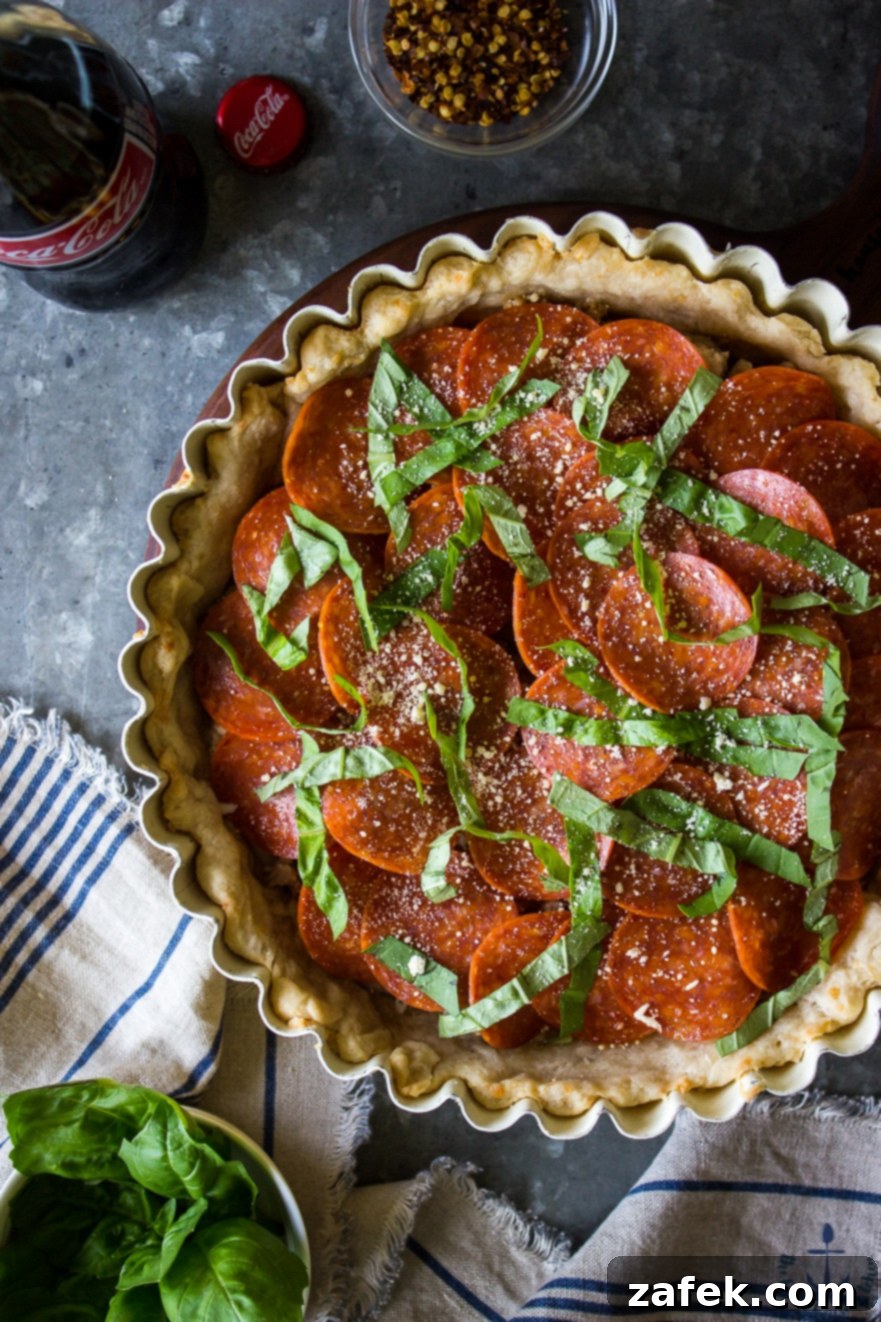 Assembling the Pepperoni and Sausage Pizza Tart with basil and cheese