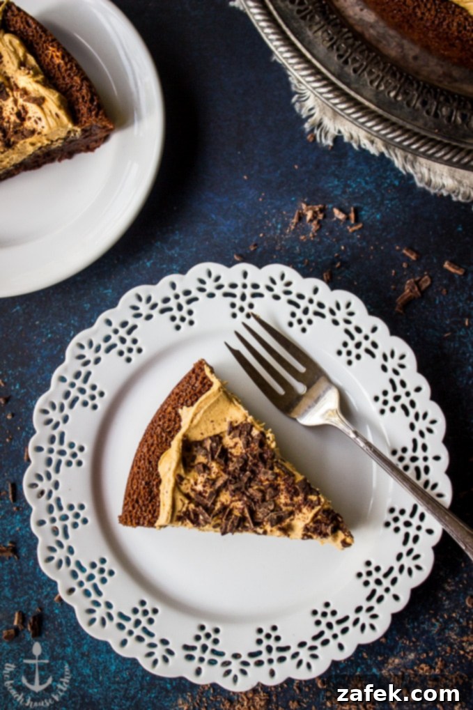 Speculoos-Brownie-Cake Beyaz dantel kenarlı bir tabakta gümüş bir çatalla servis edilen bir dilim Speculoos Brownie Pastası.