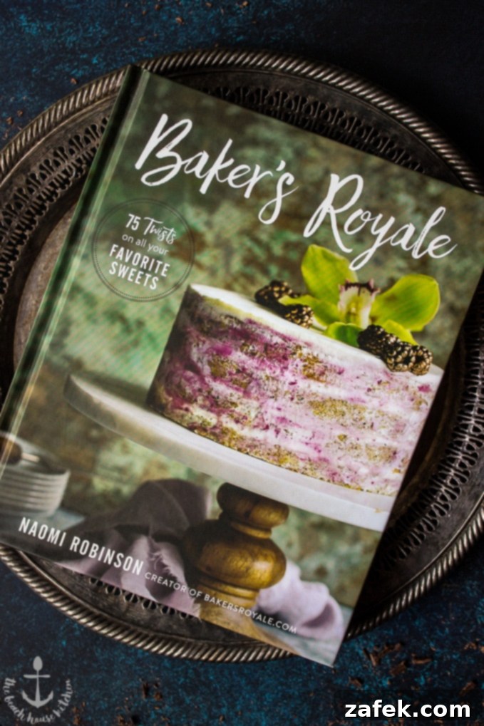 Speculoos-Brownie-Cake Gümüş bir tepsi üzerinde, üzerinde bir pasta bulunan Baker's Royale yemek kitabı kapağı.