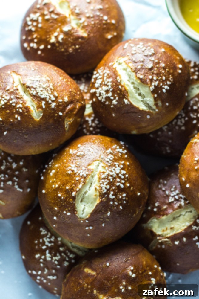 Soft Pretzel Buns 2 Golden-brown homemade pretzel rolls, perfectly salted and ready to eat, served as a dinner roll.