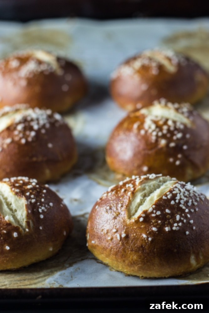 Soft Pretzel Buns 4 A close-up view of a baked pretzel roll, cut open to reveal its soft, airy interior and inviting crumb structure.