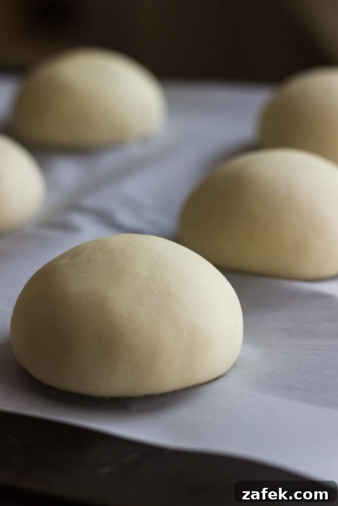 Soft Pretzel Buns 6 A gourmet sandwich showcasing a homemade pretzel roll, sliced and ready to be filled with your favorite ingredients.