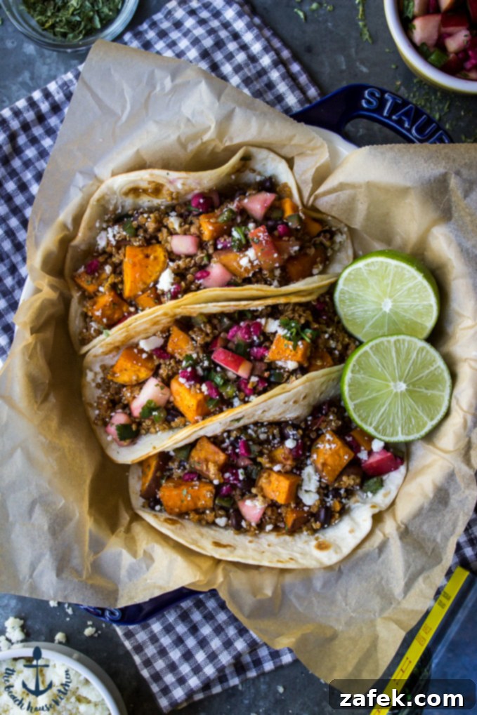 Chipotle Sweet Potato Quinoa Tacos: The Ultimate Meatless Monday Meal Three chipotle sweet potato quinoa tacos in a blue dish lined with brown parchment paper and a sliced lime, showcasing vibrant colors.