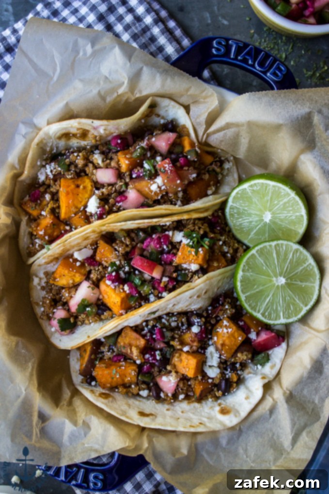 Delicious Chipotle Sweet Potato and Quinoa Tacos A close-up of three beautifully assembled chipotle sweet potato quinoa tacos in a blue dish, garnished with fresh lime, ready to be enjoyed.