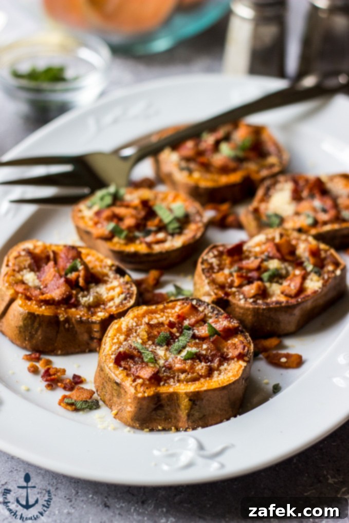 A white oval plate filled with smashed sweet potatoes, browned butter, parmesan, bacon and sage with a serving fork.