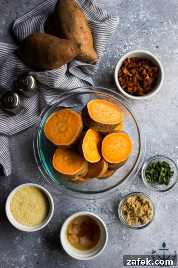 Sweet potatoes in glass bowl, bacon, parmesan, butter, chives and brown sugar in small bowls and two large sweet potatoes on striped towel.