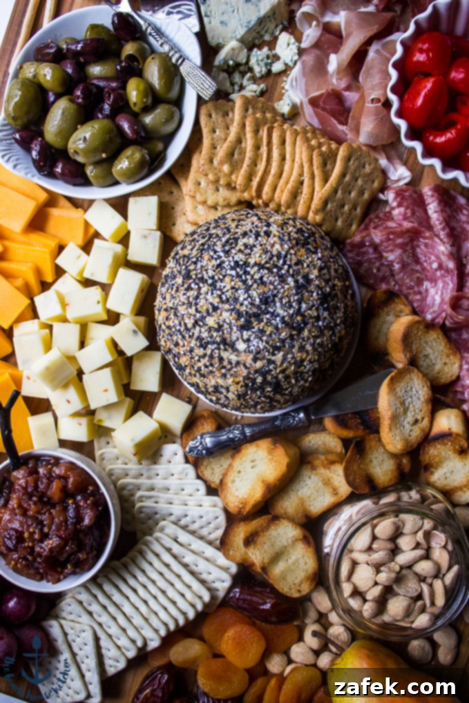 Epic Fall Cheese Board - Everything Cheddar Horseradish Cheese Ball Overhead view of an elaborate Epic Fall Cheese Board, centered around the Everything Cheddar Horseradish Cheese Ball, lavishly arranged with cured meats, fresh and dried fruits, various crackers, briny olives, and sweet peppers.
