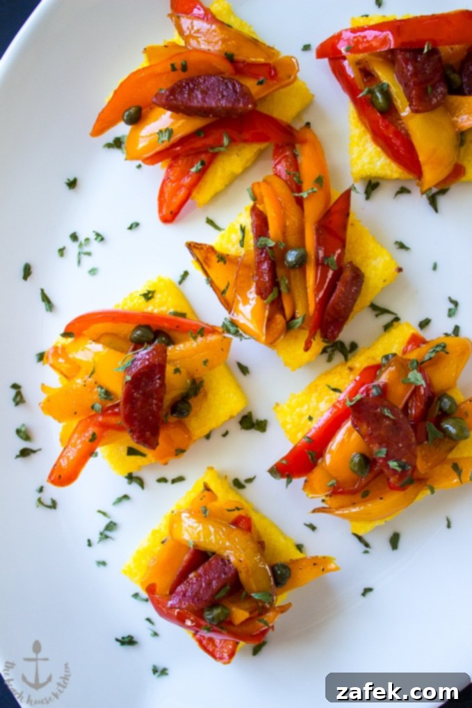 Up close photo of Sweet Pepper and Chorizo Bruschetta Polenta Bites on white platter.
