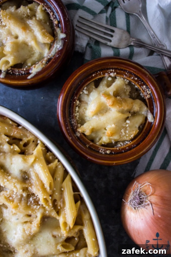 Individual Serving of French Onion Pasta A serving of French Onion Pasta in a small, elegant bowl, showcasing the rich texture of the pasta, the golden-brown melted Swiss cheese on top, and the visible caramelized onions. The dish looks inviting and perfectly cooked.