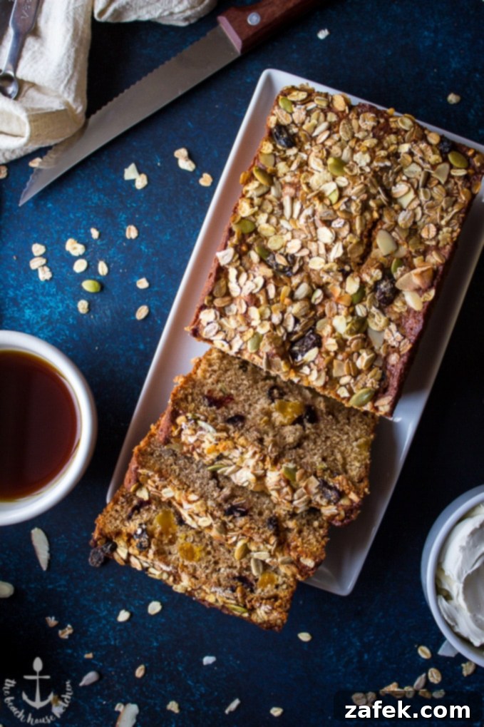 Loaded-Muesli-Quick-Bread Overhead shot of Loaded Muesli Quick Bread on a white rectangular plate with a cup of coffee and a sharp knife.
