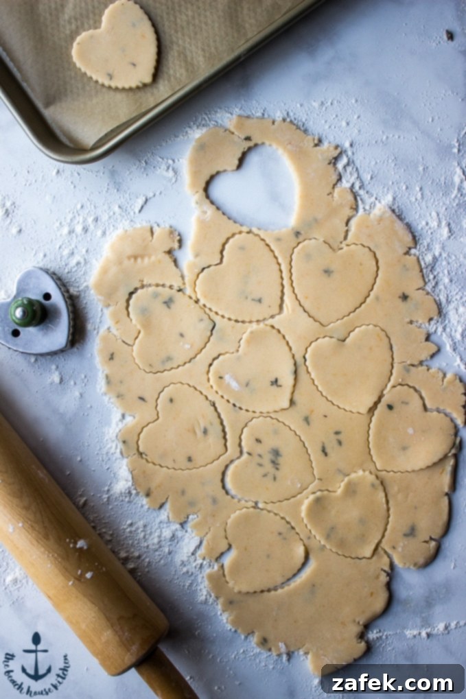 A charming overhead view showcasing the process of making shortbread: heart-shaped cutouts from cookie dough, a rolling pin, a cookie cutter, and a baking tray, set against a rustic background, indicating a homemade baking experience.
