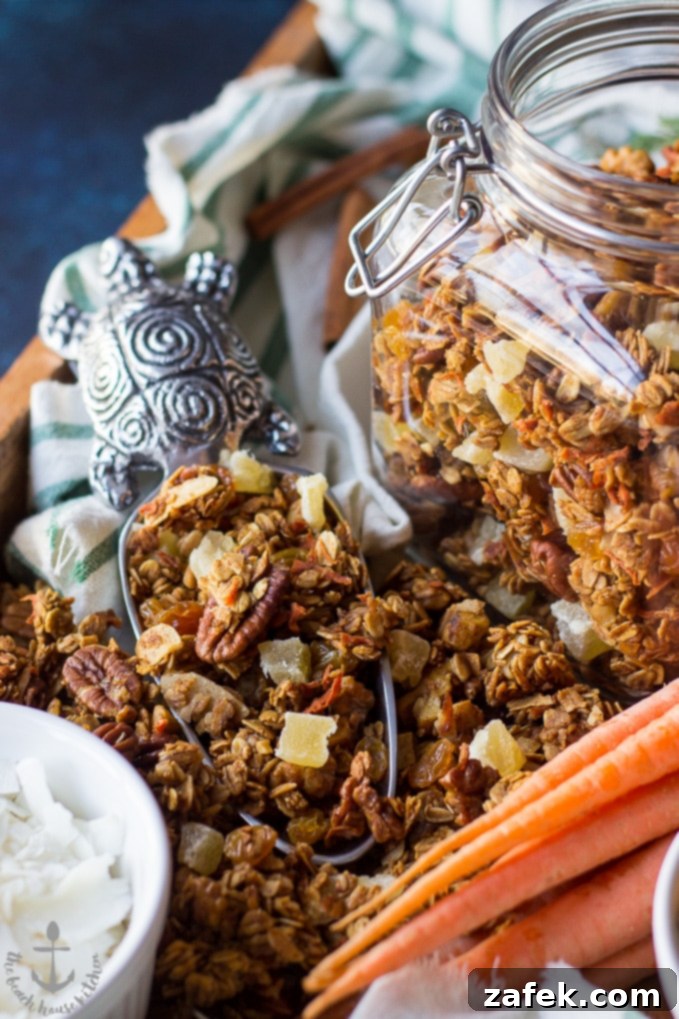 Carrot-Cake-Granola Carrot Cake Granola in a silver turtle scooper with a jar filled granola to the right.
